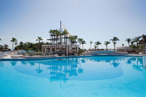 a large blue swimming pool in a resort with palm trees at Bahia Principe Grand Tulum - All Inclusive in Akumal