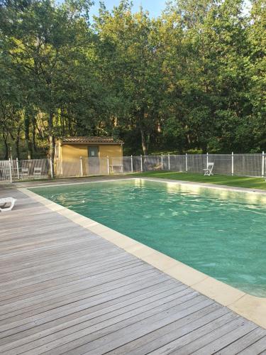 einen Pool mit einer Holzterrasse und Bäumen in der Unterkunft Mazet de Val d'Aury in Valaurie