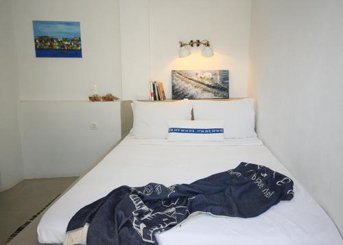 a white bed with a blanket on top of it at Kallichoron Country Houses in Astypalaia Town