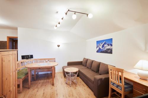 ein Wohnzimmer mit einem Sofa und einem Tisch in der Unterkunft Landhaus Lina in Wallgau