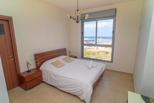 a bedroom with a bed and a large window at Luxury Marina Beachfront by Airsuite in Ashdod