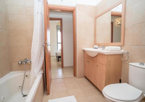 a bathroom with a sink and a tub and a toilet at Luxury Marina Beachfront by Airsuite in Ashdod