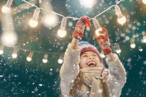 a young girl is holding lights in the snow at Forest Chalet, 15 min to salzburg olt town, and most beautiful lakes, secluded location, 1,000 sqm garden, mountainview, panorama sauna, bath whirlpool, BBQ&bikes&sunbeds for free, up to 10 p in Golling an der Salzach