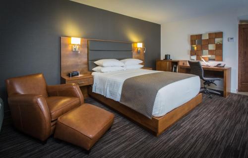 a hotel room with a bed and a desk and a chair at Atlantic Host Hotel, Trademark Collection by Wyndham in Bathurst
