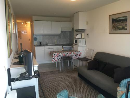 ein Wohnzimmer mit einem Sofa und einer Küche in der Unterkunft Prachtige studio met frontaal zeezicht en terras 4 pers. in Ostende