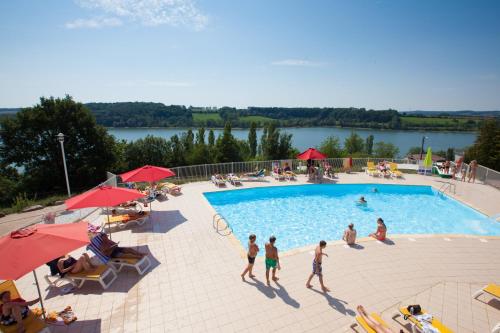 a group of people standing around a swimming pool at Camping de la Liez in Peigney