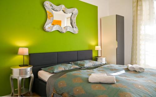 a green bedroom with a bed with a mirror on the wall at Delightful Suite Hofburg in Vienna