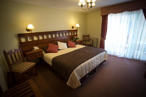 a bedroom with a large bed and a window at El Copihue Olmué in Olmué