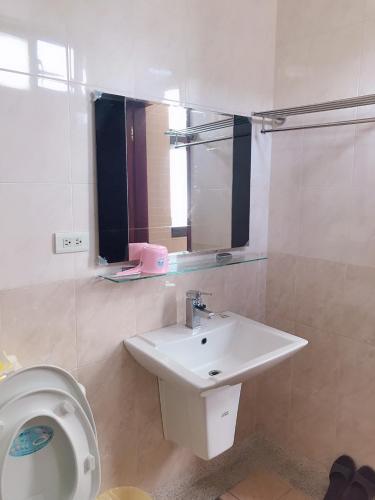 a bathroom with a sink and a toilet at Funny Eggs Guest House in Tainan
