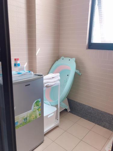a pink bathroom with a toilet and a sink at Funny Eggs Guest House in Tainan