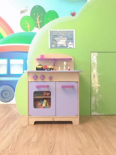 a childs play kitchen with a toy stove in a room at Funny Eggs Guest House in Tainan