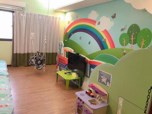 台南的住宿－台南小搗蛋親子民宿，墙上有彩虹壁画的儿童房