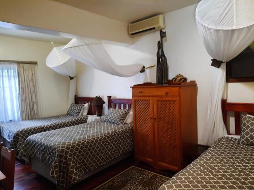 a bedroom with two beds and a dresser at St. Lucia Wetlands Guest House in St Lucia