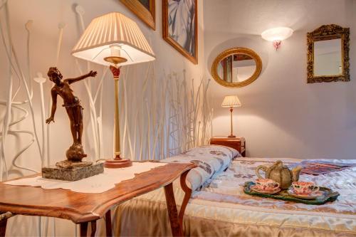 a bedroom with a table with a statue on a bed at Villa La Favorita in Alba