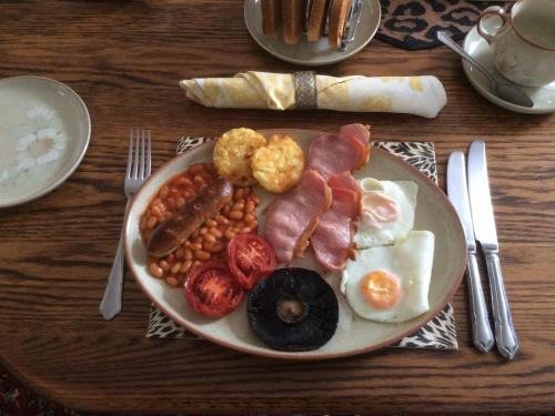 um prato de comida de pequeno-almoço com ovos, feijão e salsicha em Laurel Lodge em Horncastle