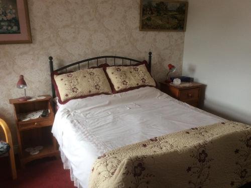 ホーンキャッスルにあるLaurel Lodgeのベッドルーム(ナイトスタンド2台、テーブル2台付)のベッド1台