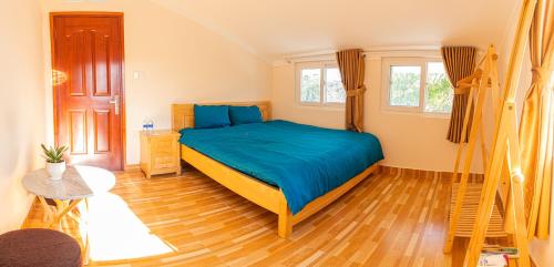 a bedroom with a bed and a wooden floor at Caly homestay in Da Lat