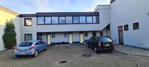 two cars parked in a parking lot in front of a house at Hotel zur Riede bei Bremen in Delmenhorst