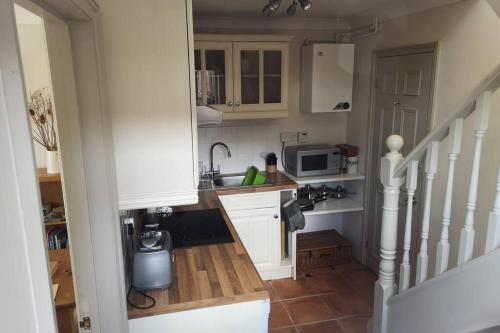 una pequeña cocina con fregadero y microondas en Blakeney Norfolk Bramble Lodge ***Self Catering*** en Blakeney
