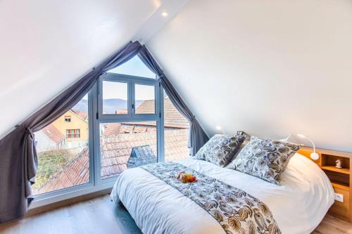 ein Schlafzimmer mit einem Bett und einem großen Fenster in der Unterkunft Gîte La Rodernelle - Sauna privatif - Climatisation - Vue sur le Château du Haut Kœnigsbourg in Rodern