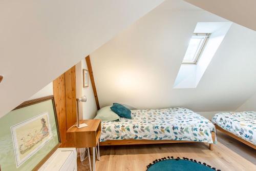 a attic bedroom with two beds and a window at Gîte La Rodernelle - Sauna - Patio - Climatisation - Vue sur Château du Haut Kœnigsbourg in Rodern