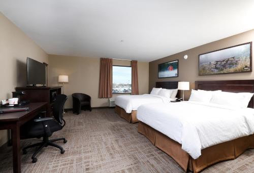 Habitación de hotel con 2 camas y escritorio en Canad Inns Destination Centre Transcona, en Winnipeg