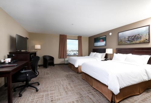 a hotel room with two beds and a desk at Canad Inns Destination Centre Transcona in Winnipeg