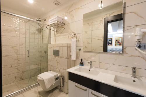 a bathroom with a sink and a toilet and a shower at Florya Novi Hotel in Istanbul