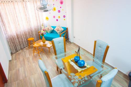 a living room with a glass table and blue chairs at El Velero Apartamentos By DANP in Santa Marta