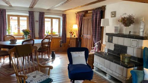 un salon avec une table et une cheminée dans l'établissement Le Nid de Cigognes, à Hengwiller