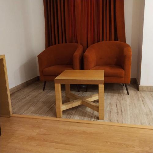 a living room with a chair and a table at PPH Living Railotel Coimbatore in Coimbatore
