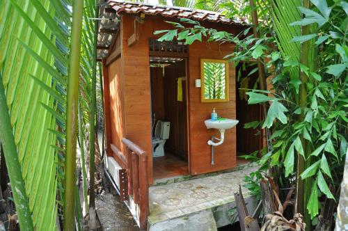 a bathroom with a sink and a toilet in a forest at Ben Tre Farm Stay in Ben Tre