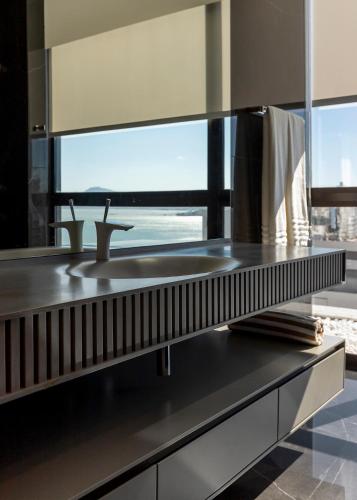 a kitchen with a sink and a large window at LK Design Hotel Florianópolis in Florianópolis