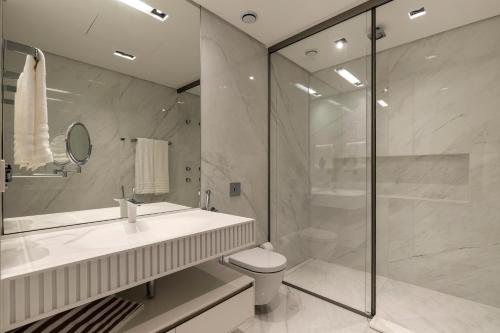 a bathroom with a shower and a toilet and a sink at LK Design Hotel Florianópolis in Florianópolis