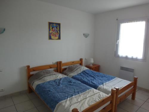 une chambre avec un lit en bois et une fenêtre dans l'établissement Orée de La Dune, à Biscarrosse-Plage