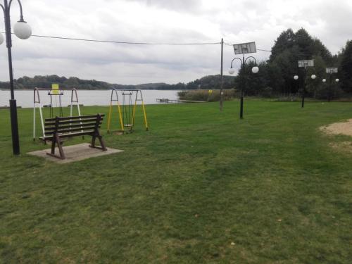 a park with a swing set and a playground at Domek na Mazurach Leśne Zacisze in Ostaszewo