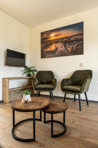 two chairs and a coffee table in a room at 't Eibernest in De Cocksdorp