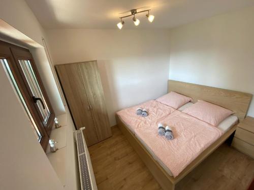 Dormitorio pequeño con cama con sábanas rosas en Ferienhaus Nele en Hilders