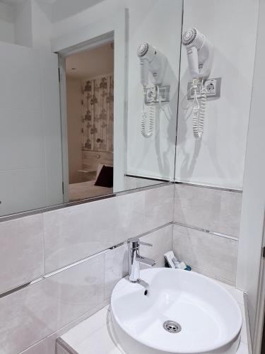 un bagno con un lavandino bianco e uno specchio di Hostal Met Madrid a Madrid