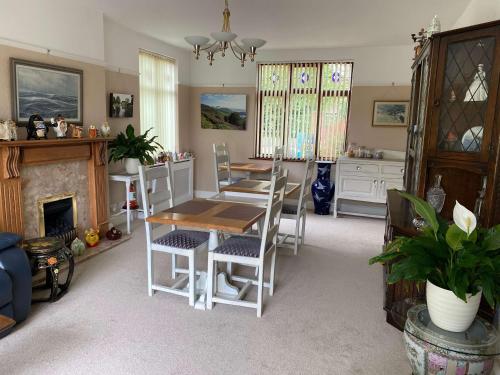 a dining room with a table and chairs and a fireplace at Orchard Side Bed and Breakfast in Great Malvern