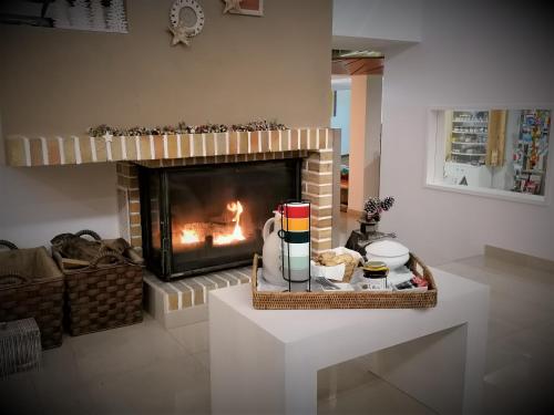 a living room with a fireplace and a table with food at Boutique Hotel Casa do Outeiro - Arts & Crafts in Batalha