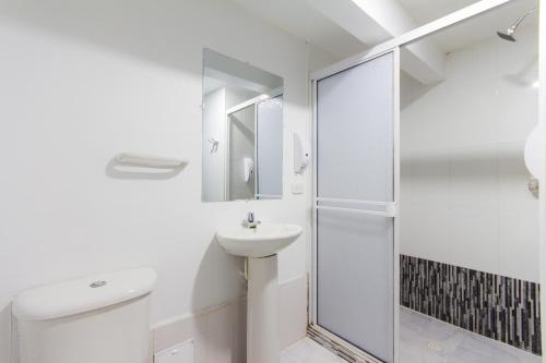 e bagno con servizi igienici, lavandino e doccia. di Hotel Bocagrande By GEH Suites a Cartagena de Indias
