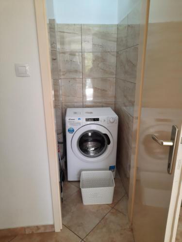 - un lave-linge et un sèche-linge dans une petite salle de bains dans l'établissement Apartments Villa Beba, à Komiža