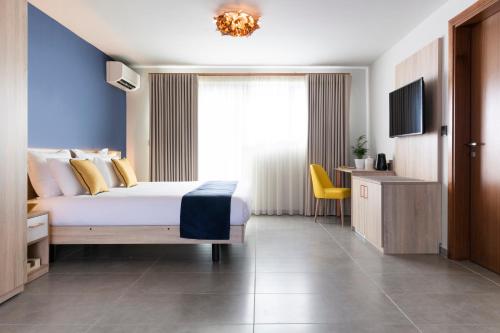 a hotel room with a bed and a window at Antoniel Suites in St Julian's