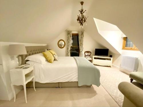 a large white bedroom with a bed and a desk at The Old Doctors Retreat- Near Soho Farmhouse in Sandford Saint Martin