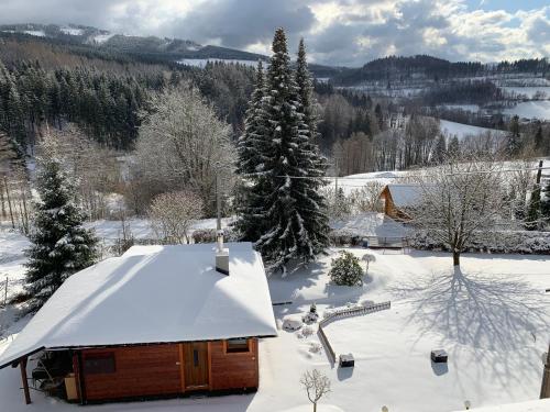a cabin with a snow covered roof in the snow at Chata HANA in Jeseník