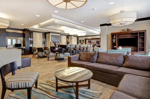 een woonkamer met een bank en tafels en stoelen bij Holiday Inn Express Hotel & Suites Waterloo - St. Jacobs Area, an IHG Hotel in Waterloo