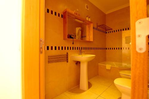 La salle de bains est pourvue d'un lavabo et de toilettes. dans l'établissement Olhos De Água 1BR with Pool, AC and Free Parking, à Albufeira