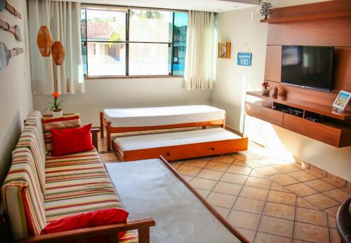 a living room with a couch and a tv at Apartamento no Condomínio Varandas do Sol in Porto Seguro