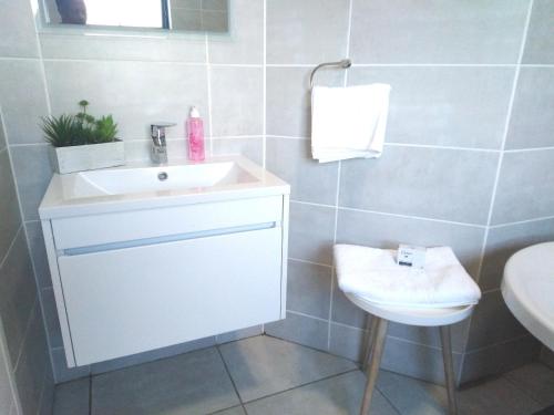 a white bathroom with a sink and a toilet at The Blyde Riverwalk Estate, R104 Bronkhorstspruit Road in Pretoria